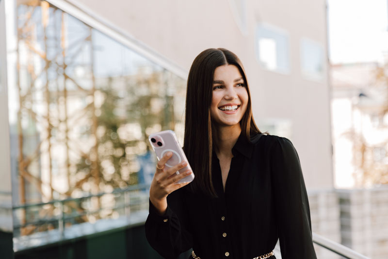Frau hat Handy in der Hand und lacht